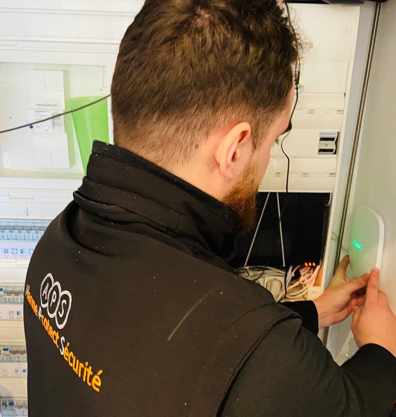 Un homme répare le boîtier d'une alarme à incendie