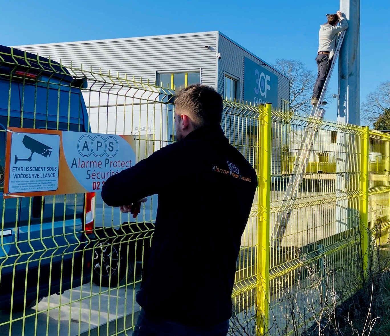 Un homme devant un grillage