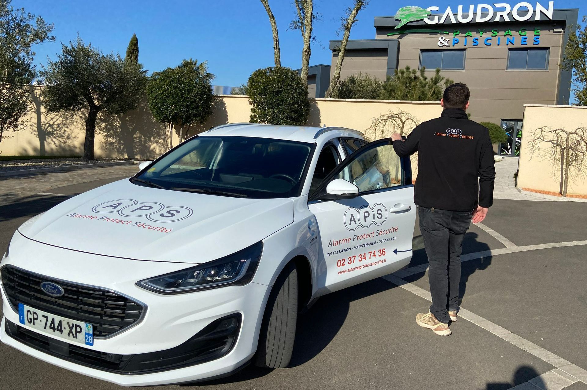 Un homme devant un magasin de piscines et de paysage