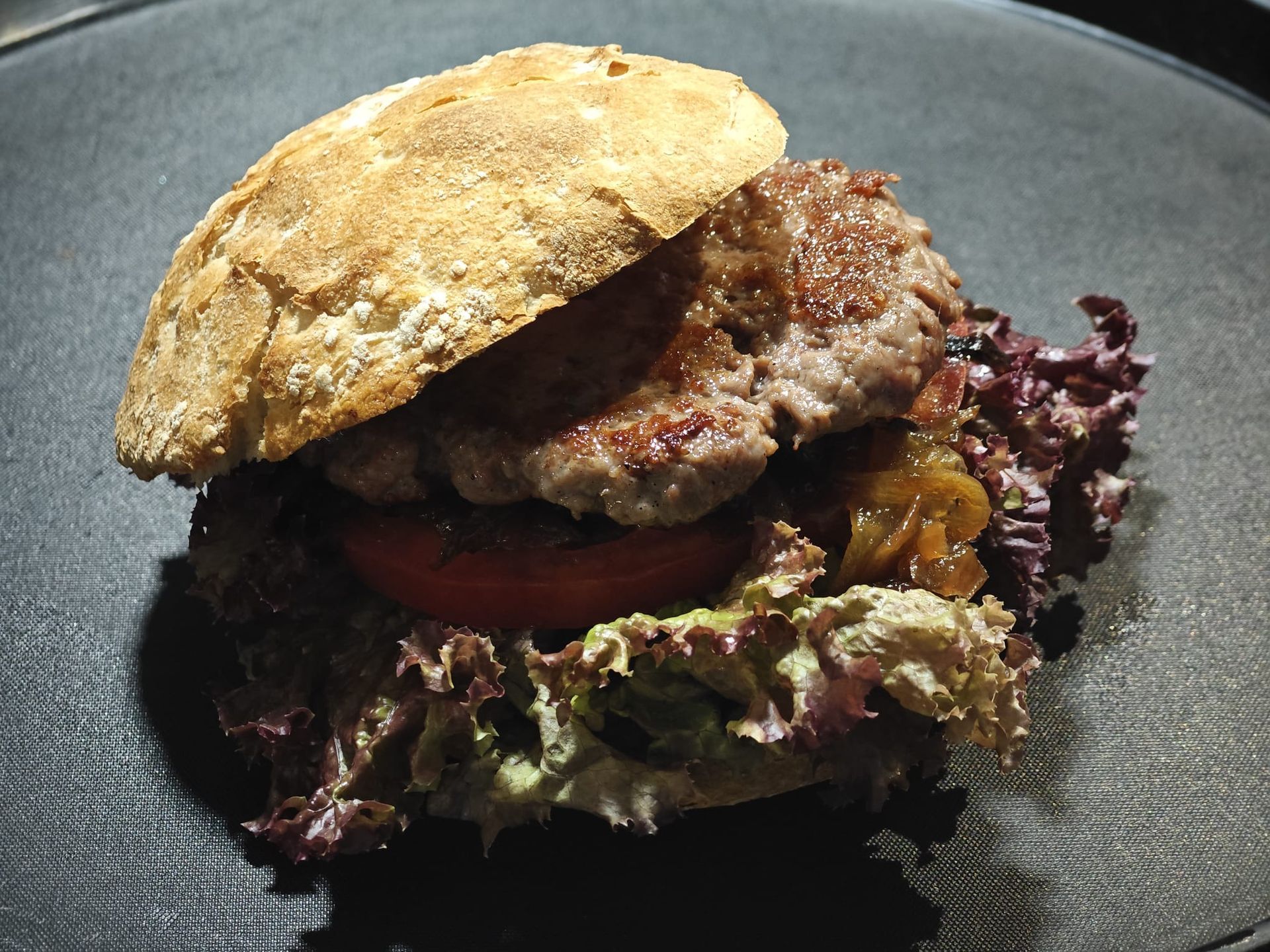 Cucharas llenas de tomates y pimientos verdes sobre una mesa