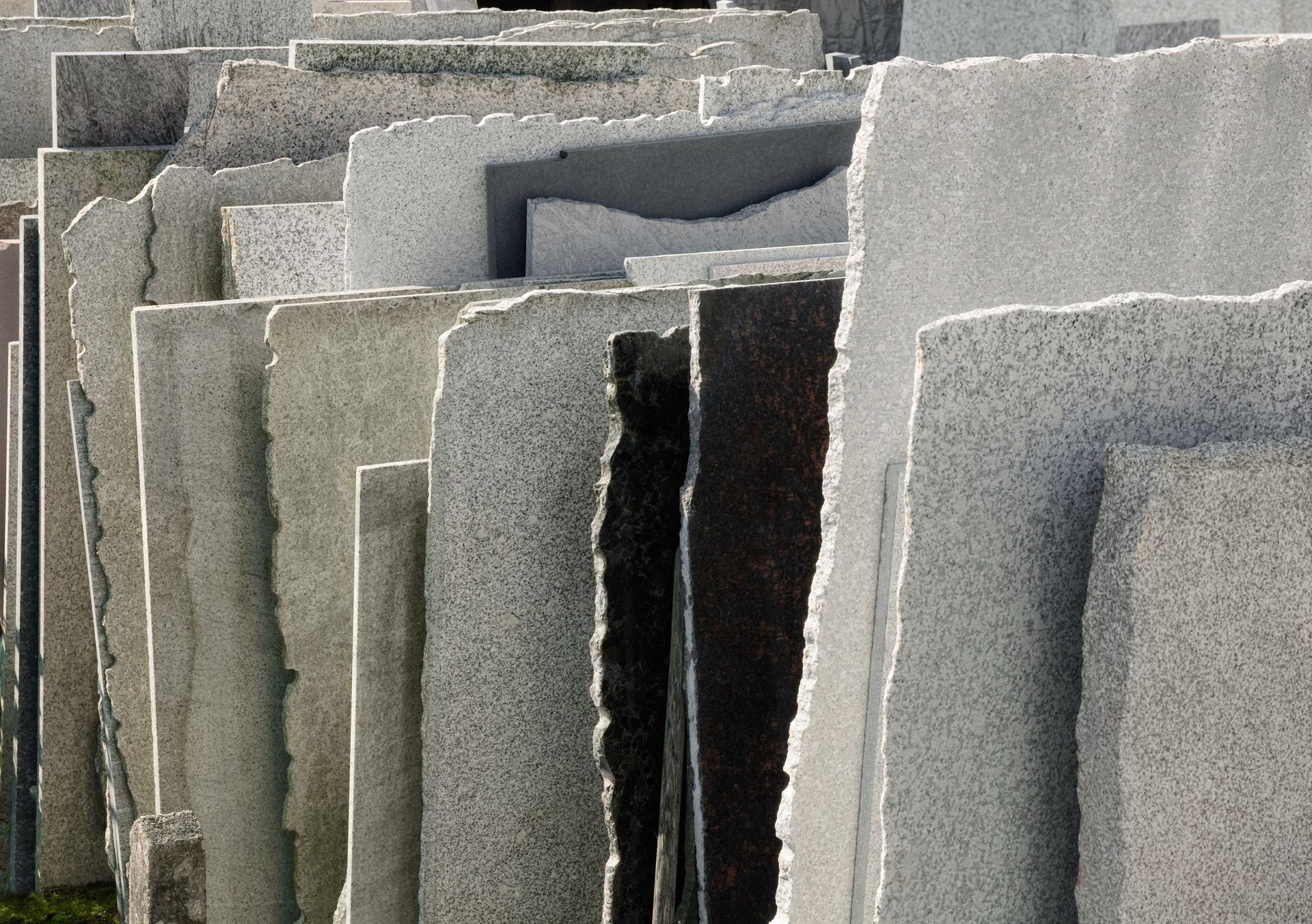 Dalles ou panneaux de béton gris empilés et disposés verticalement à l'extérieur.