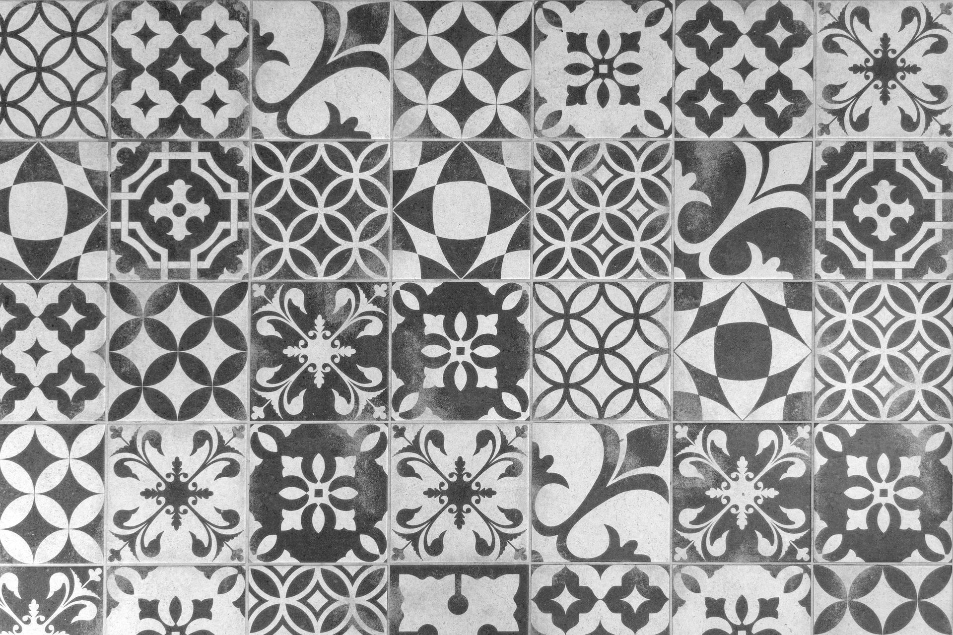 Mosaïque de carreaux géométriques noirs et blancs à motifs floraux et d'étoiles répétitifs