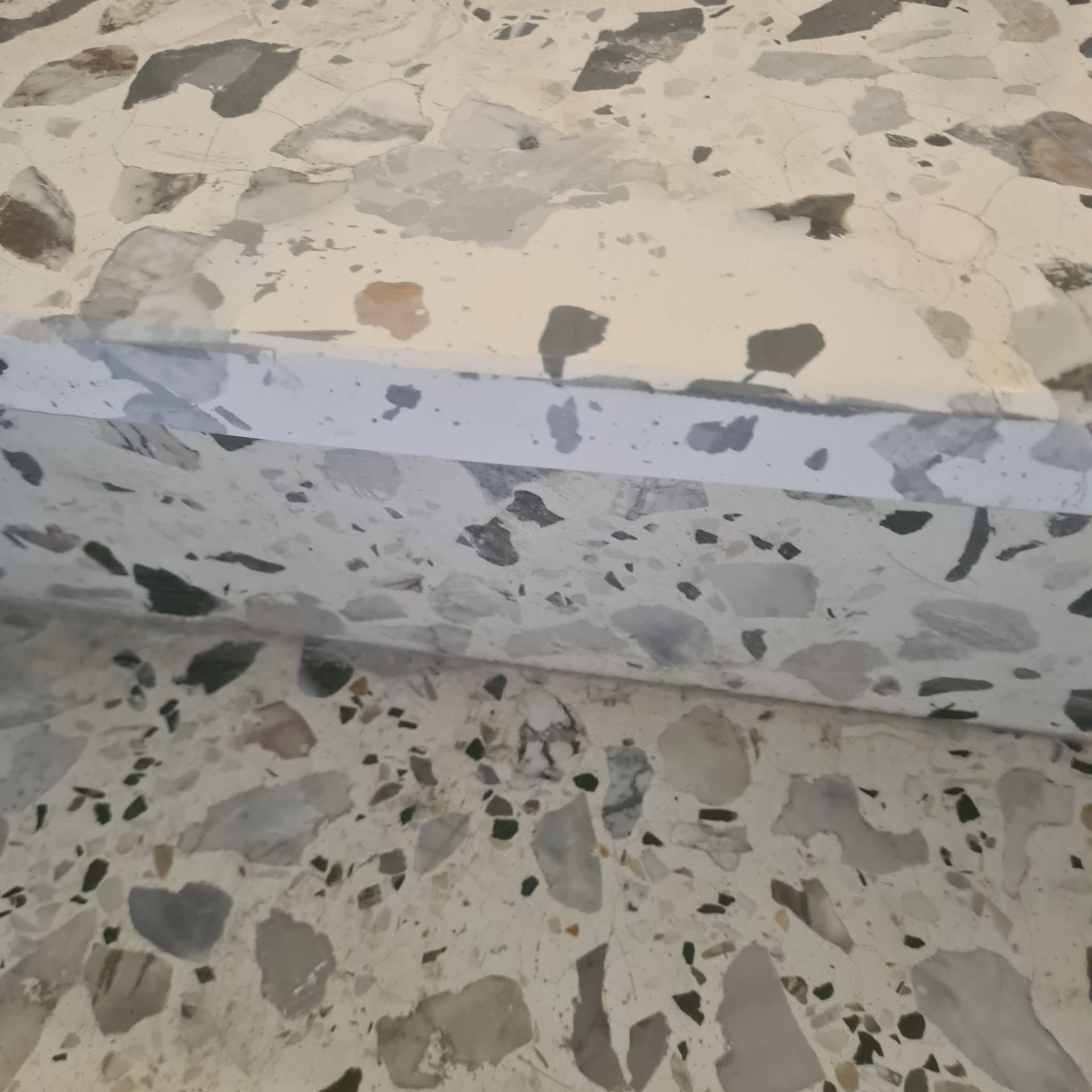 Bordure d'escalier en terrazzo avec marche gris clair et surface en pierre mouchetée