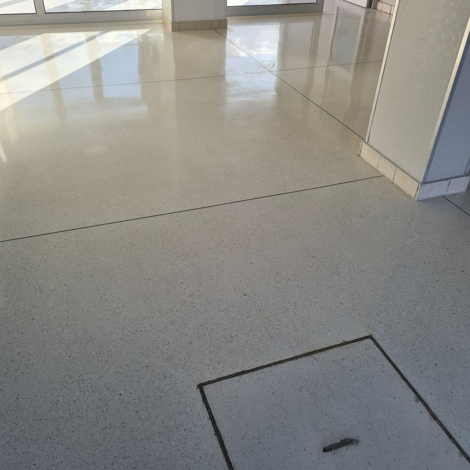 Sol intérieur vide avec carrelage gris clair brillant et une trappe d'accès carrée