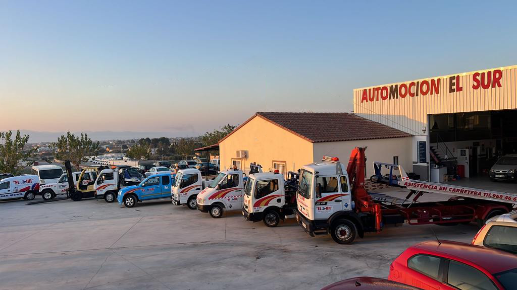 Camiones de remolque alineados afuera de un edificio rotulado