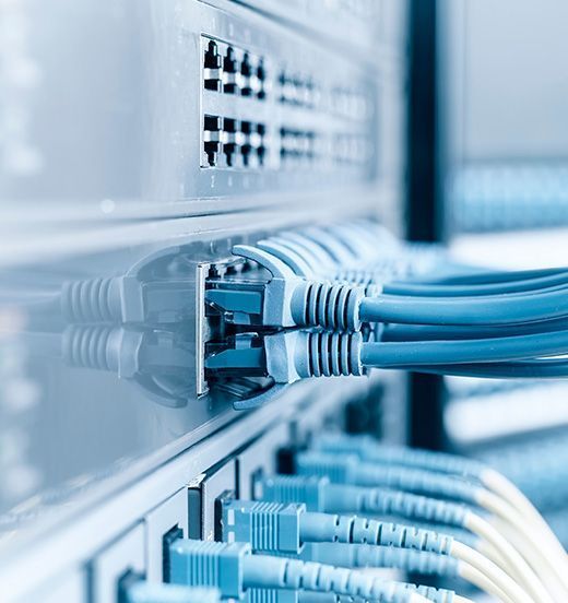 Ein Bündel blauer Kabel ist an einen Server angeschlossen.