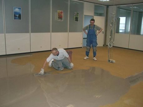 Nach dem Abschleifen der alten Kleberrückstände wird der Unterboden mit einer Grundierung vollflächig eingestrichen und anschließend mindestens 2 mm stark mit einer Systemausgleichmasse gespachtelt oder geraktelt.