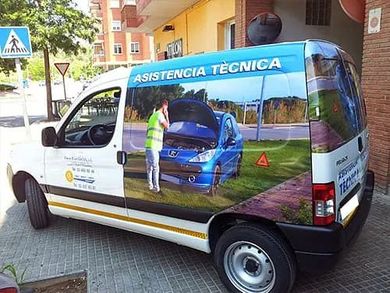 Furgoneta con el logotipo de “Asistencia Técnica” estacionada en una calle de la ciudad.