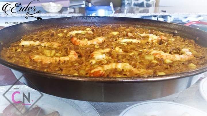Una sartén llena de arroz y camarones está sobre una mesa.