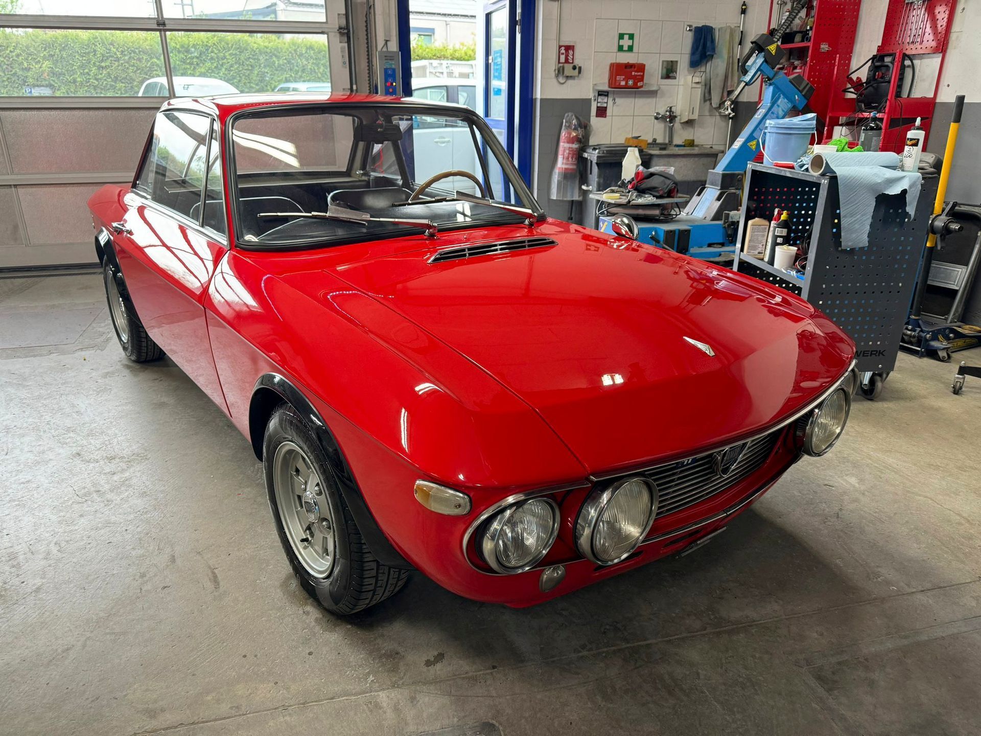 Ein rotes Auto steht in einer Garage.