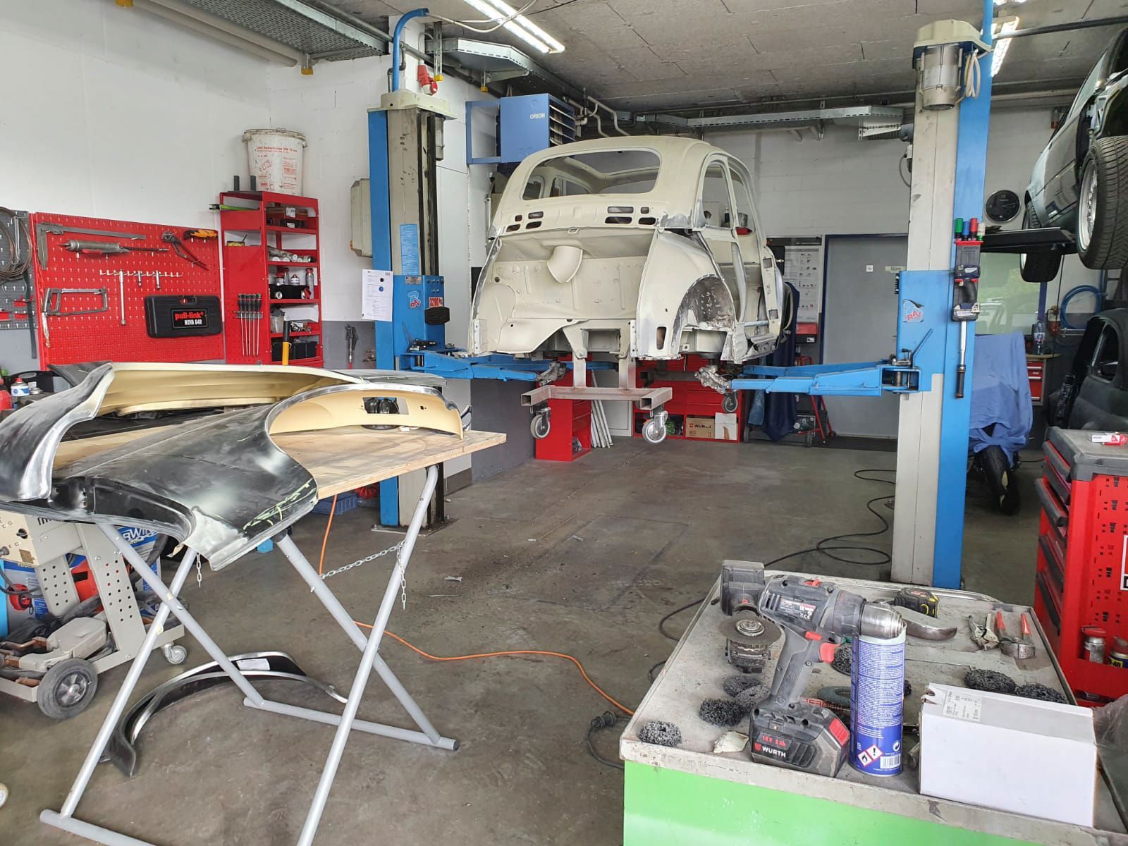 Ein Auto steht auf einer Hebebühne in einer Garage.