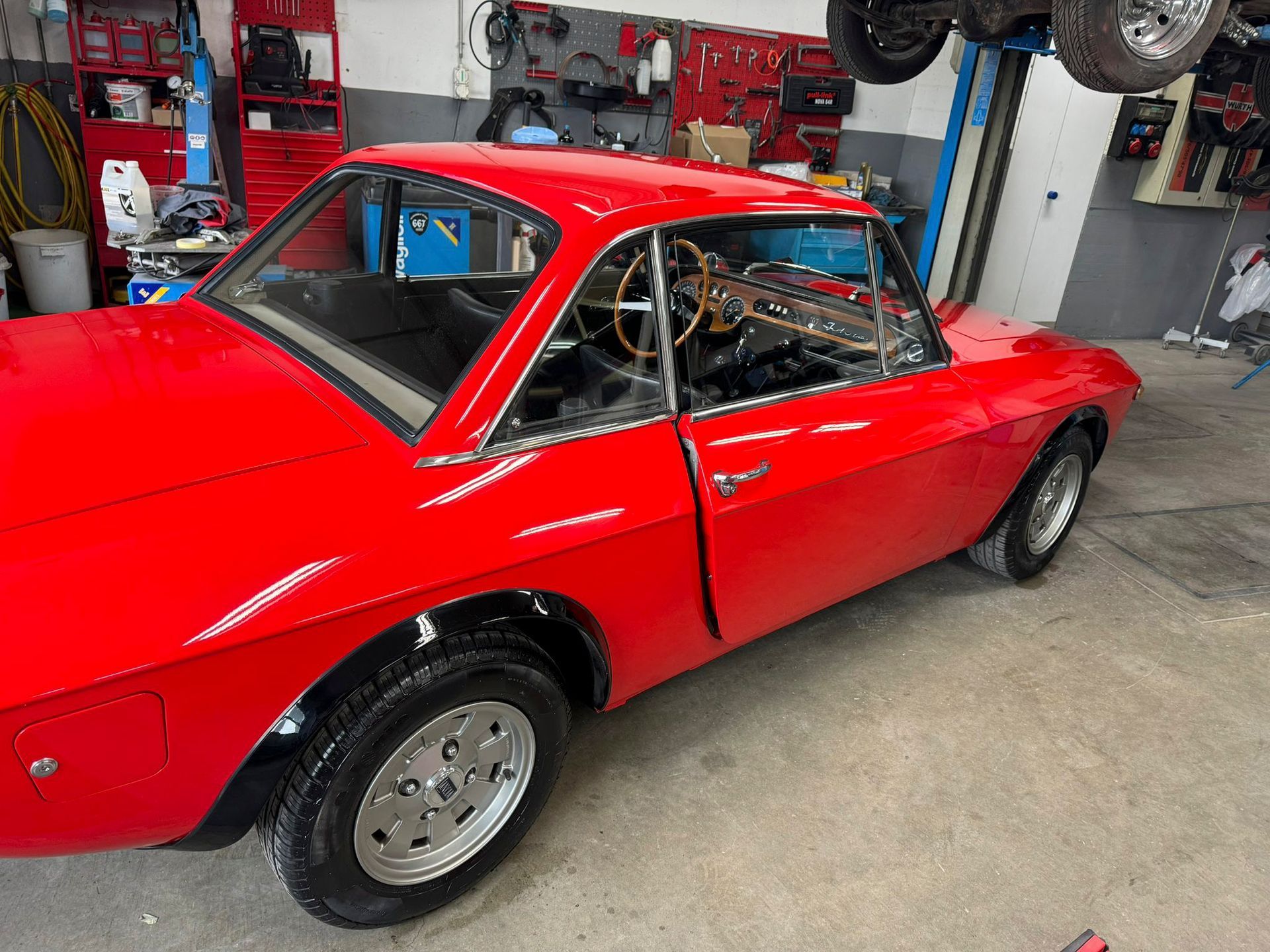 Ein rotes Auto ist in einer Garage geparkt.