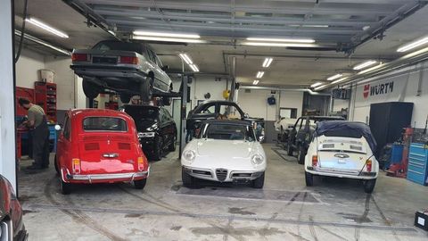 Eine Gruppe von Autos ist in einer Garage geparkt.