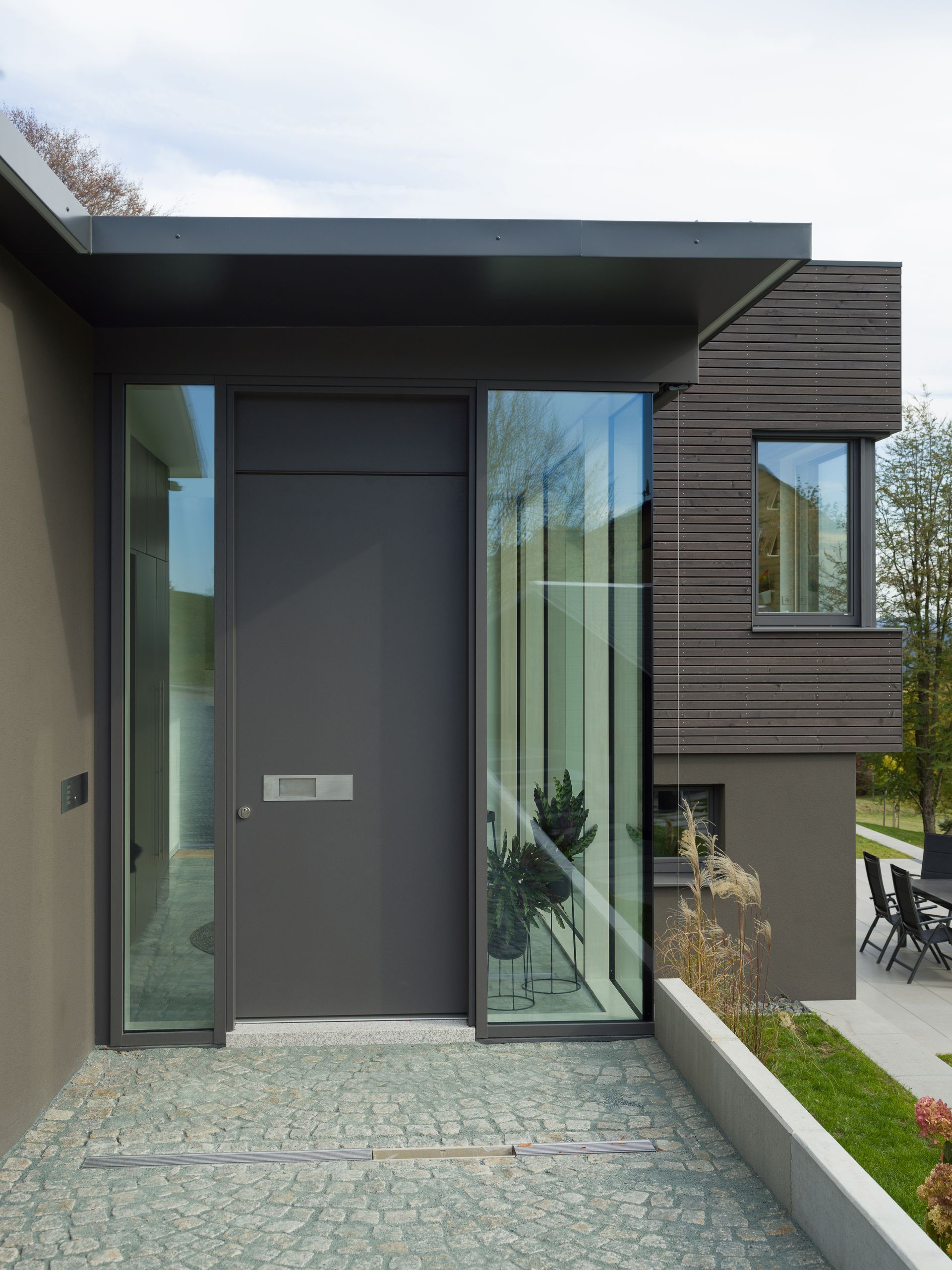 Ein modernes Haus mit einer großen Glastür und Fenstern