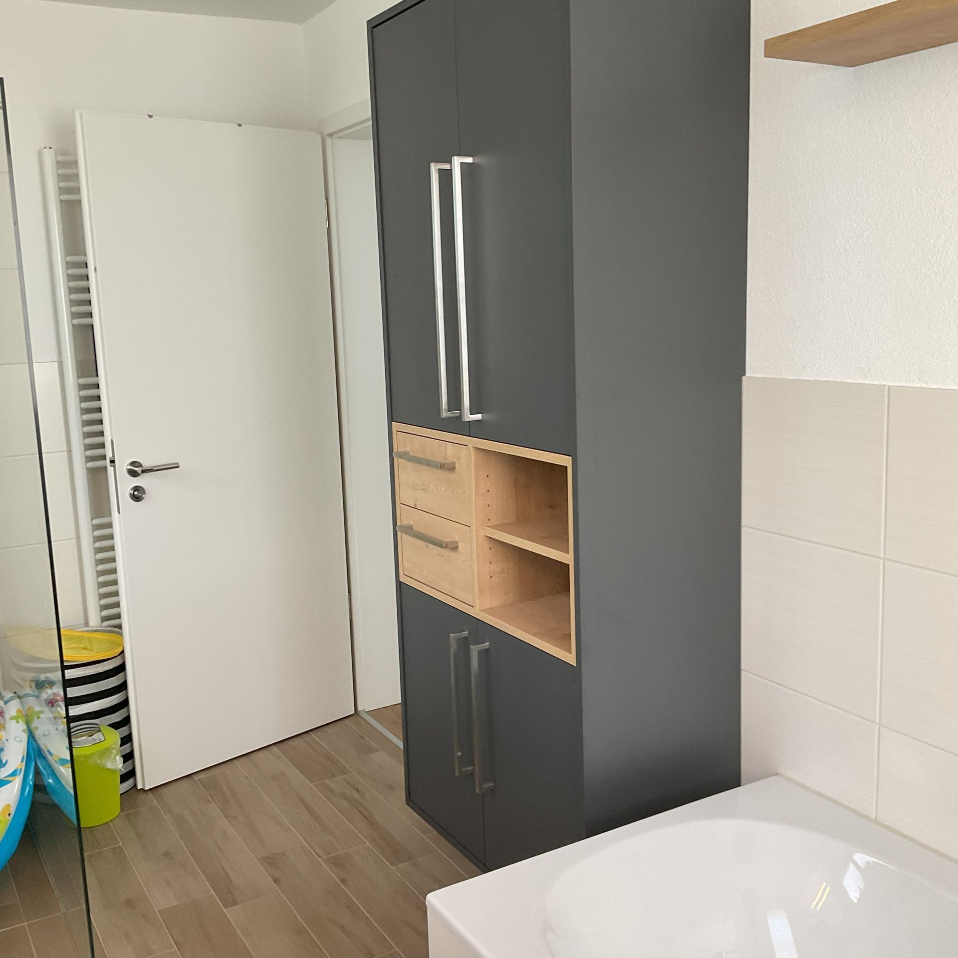 Ein Badezimmer mit großem Schrank und Badewanne