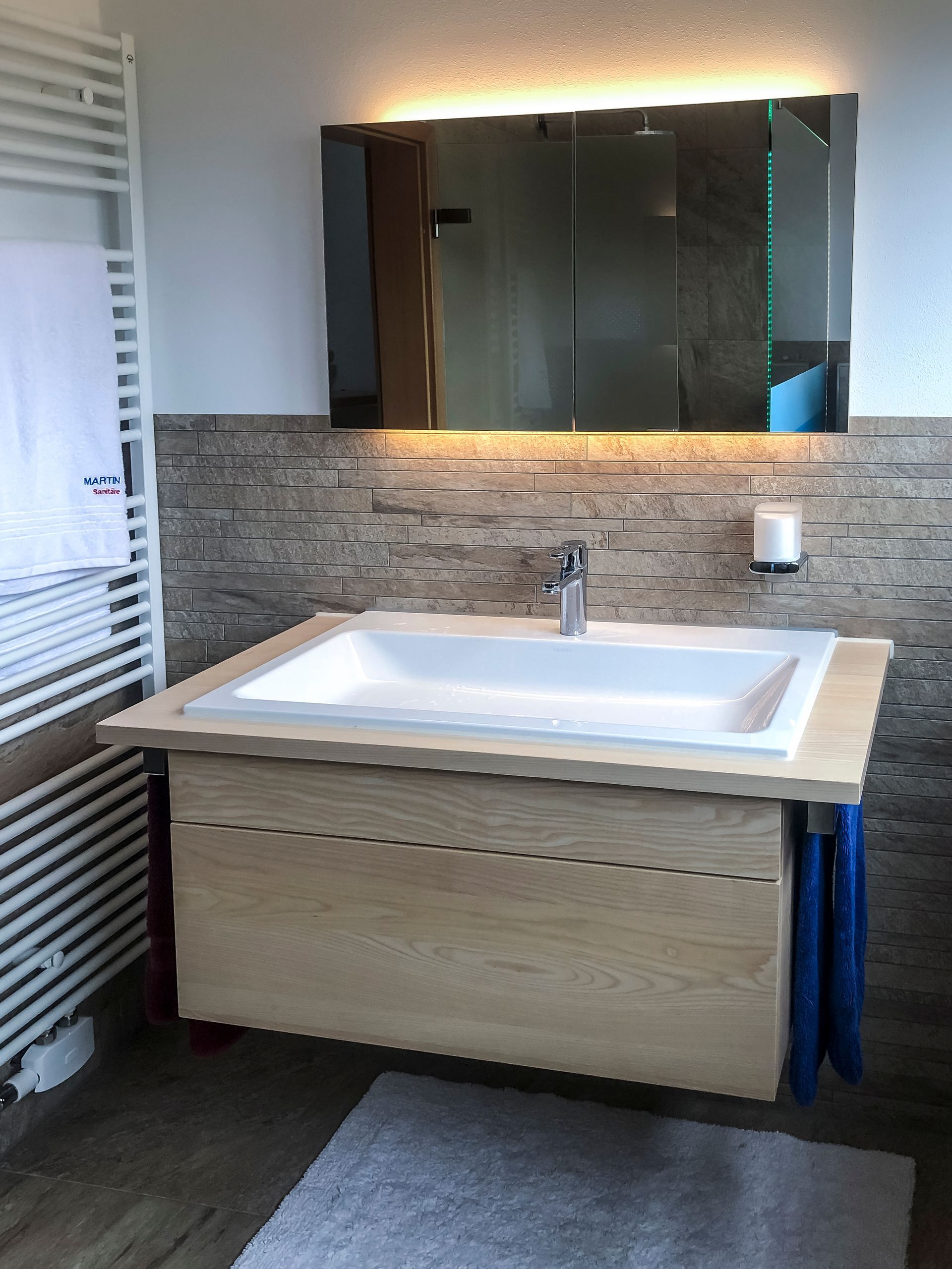 Ein Badezimmer mit großem Waschbecken und Spiegel