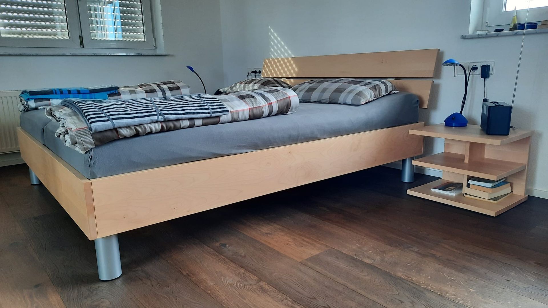 Ein Schlafzimmer mit einem Holzbett und einem Nachttisch