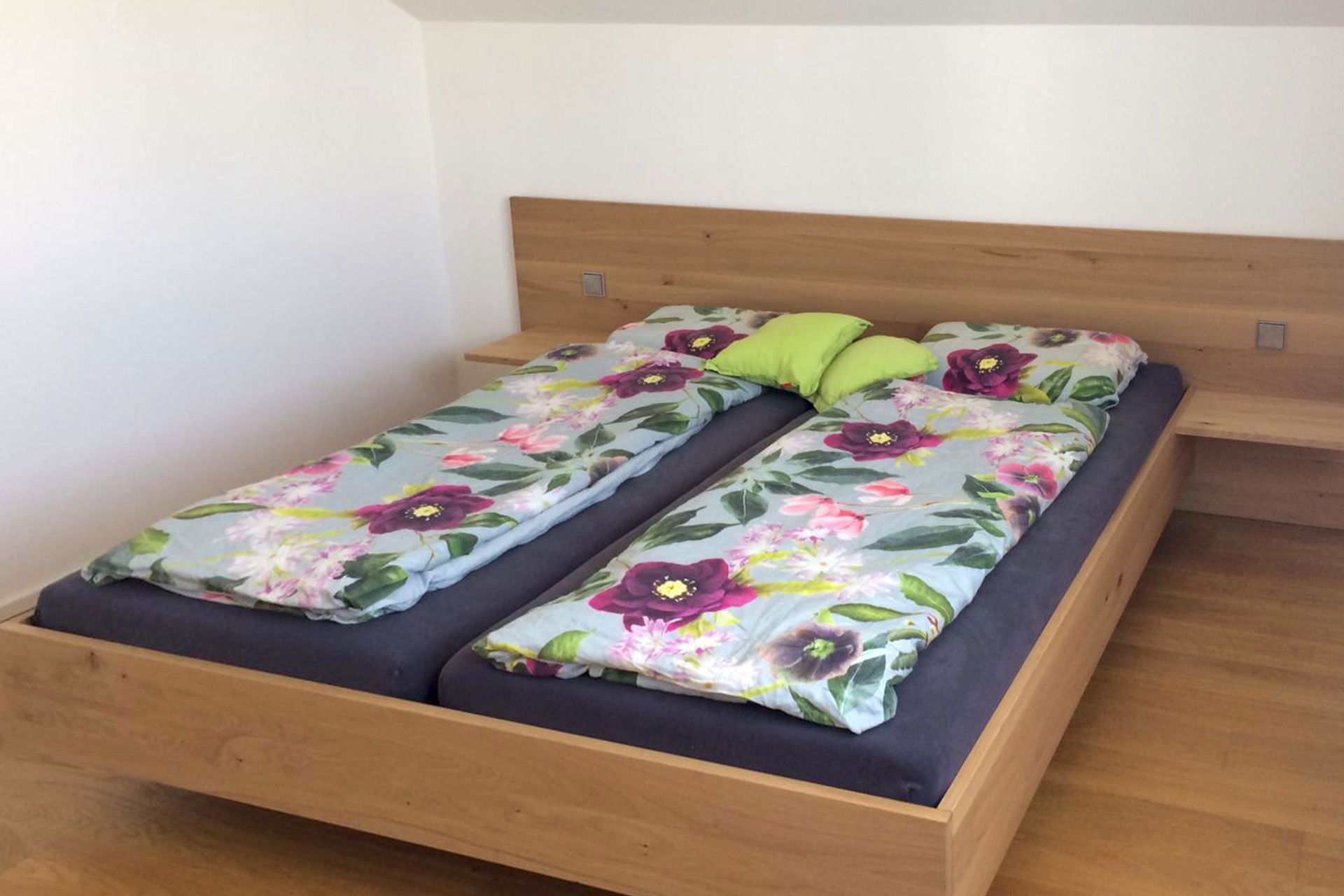 Ein Schlafzimmer mit zwei Betten und einem hölzernen Kopfteil.