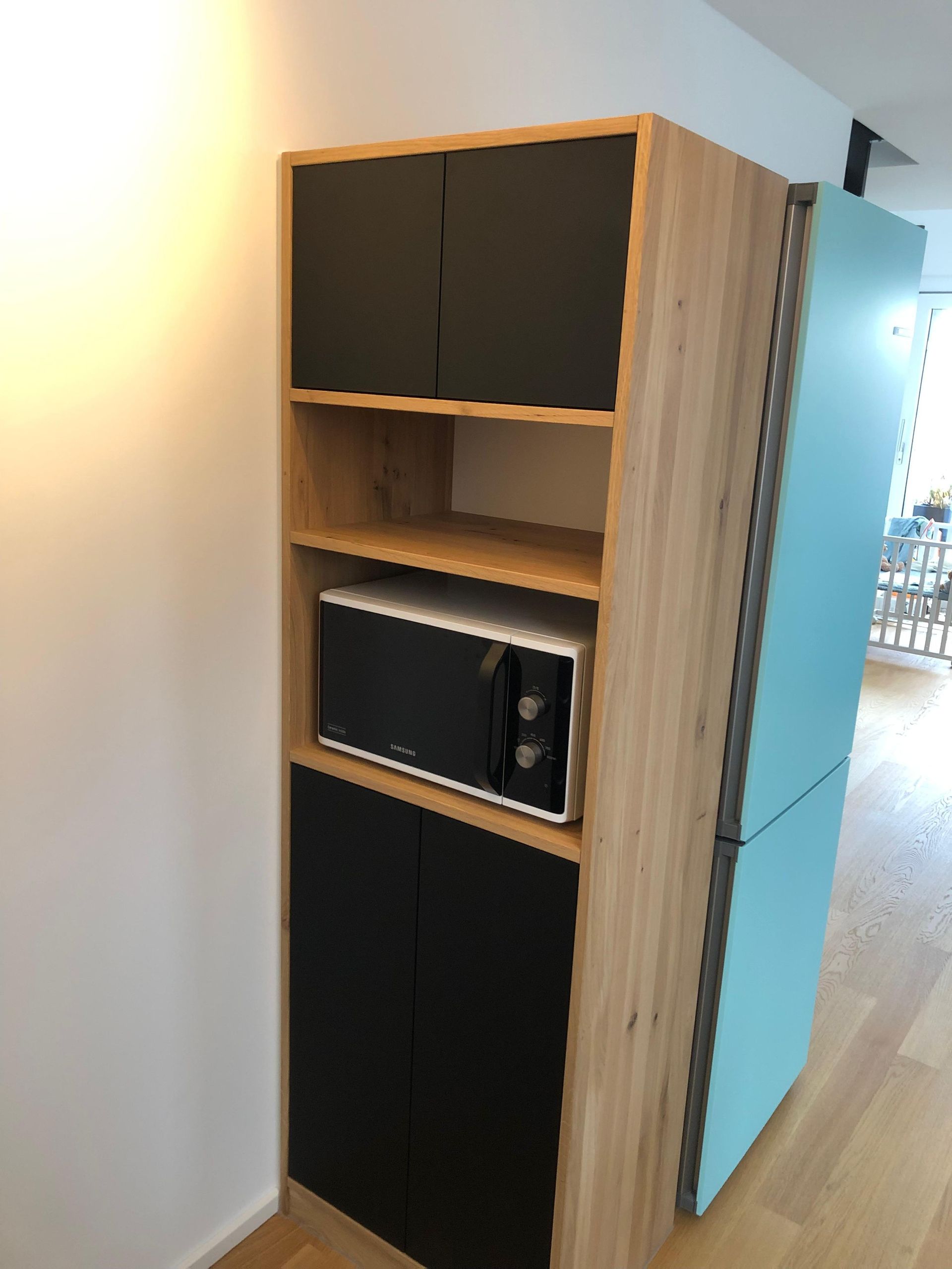 Ein Holzschrank mit einer Mikrowelle darauf