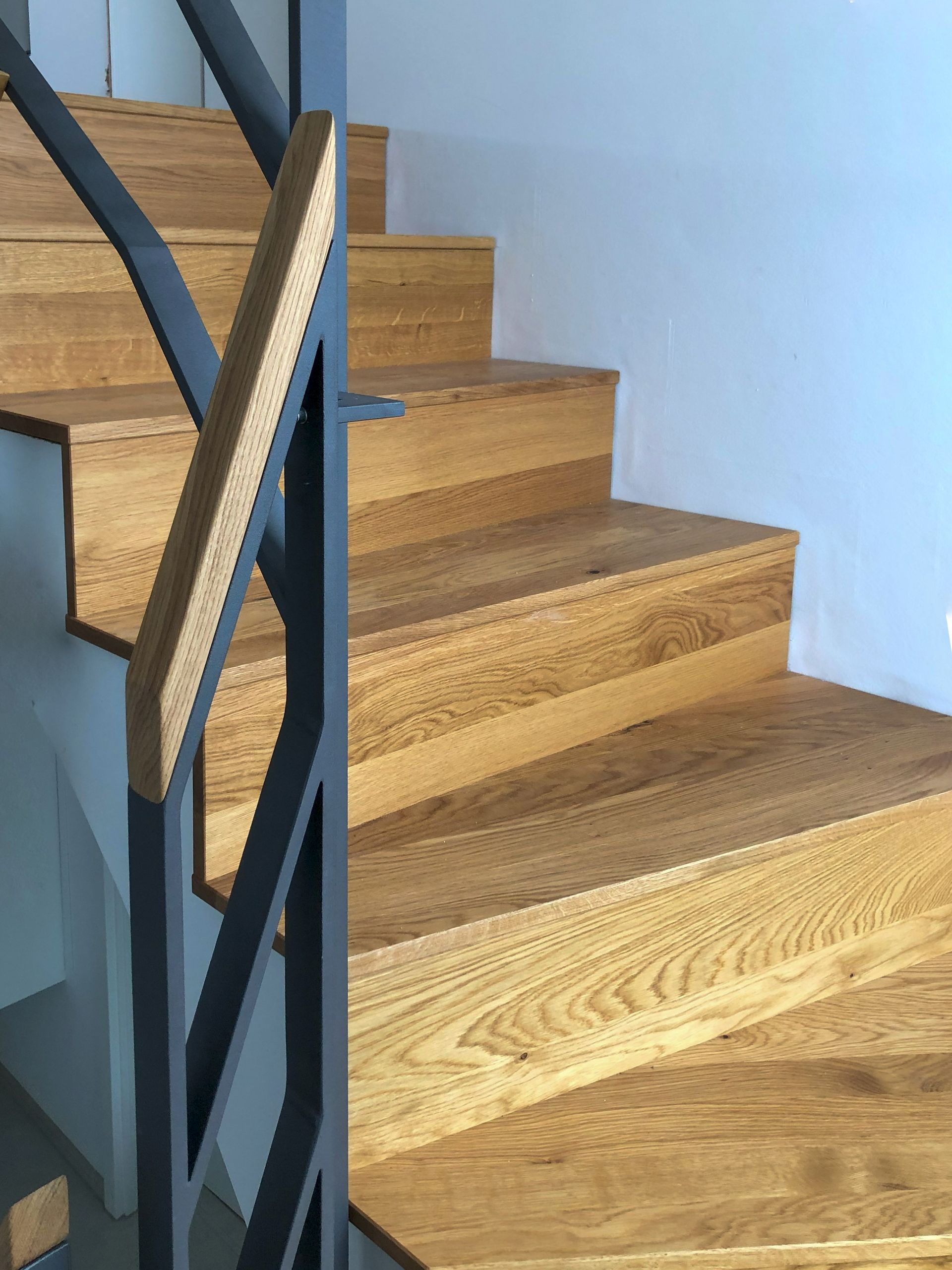 Eine Nahaufnahme einer Holztreppe mit einem Metallgeländer.