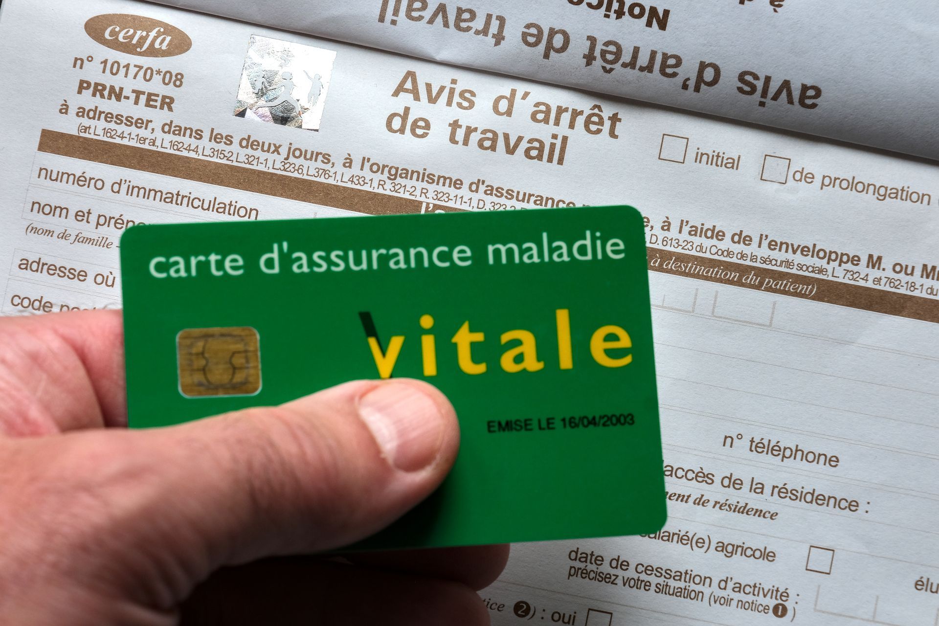 Main tenant une carte d'Assurance maladie.