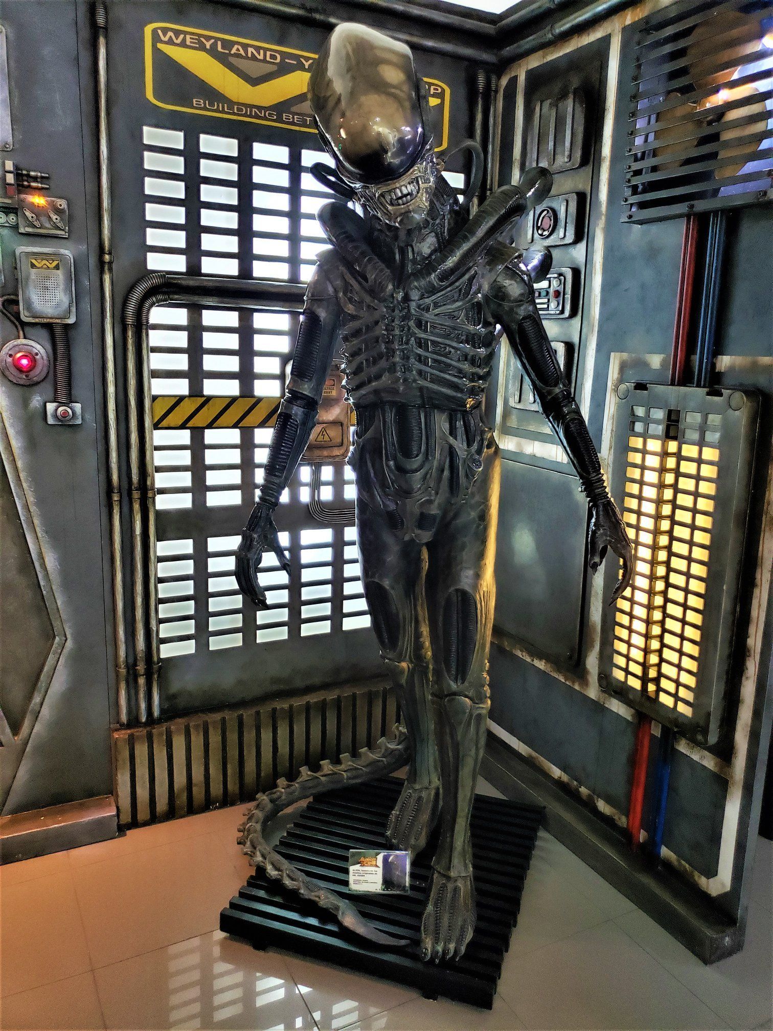 Una estatua de un extraterrestre está parada en una habitación.