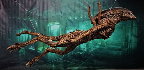 Una estatua de un extraterrestre flota en el aire en una habitación oscura.