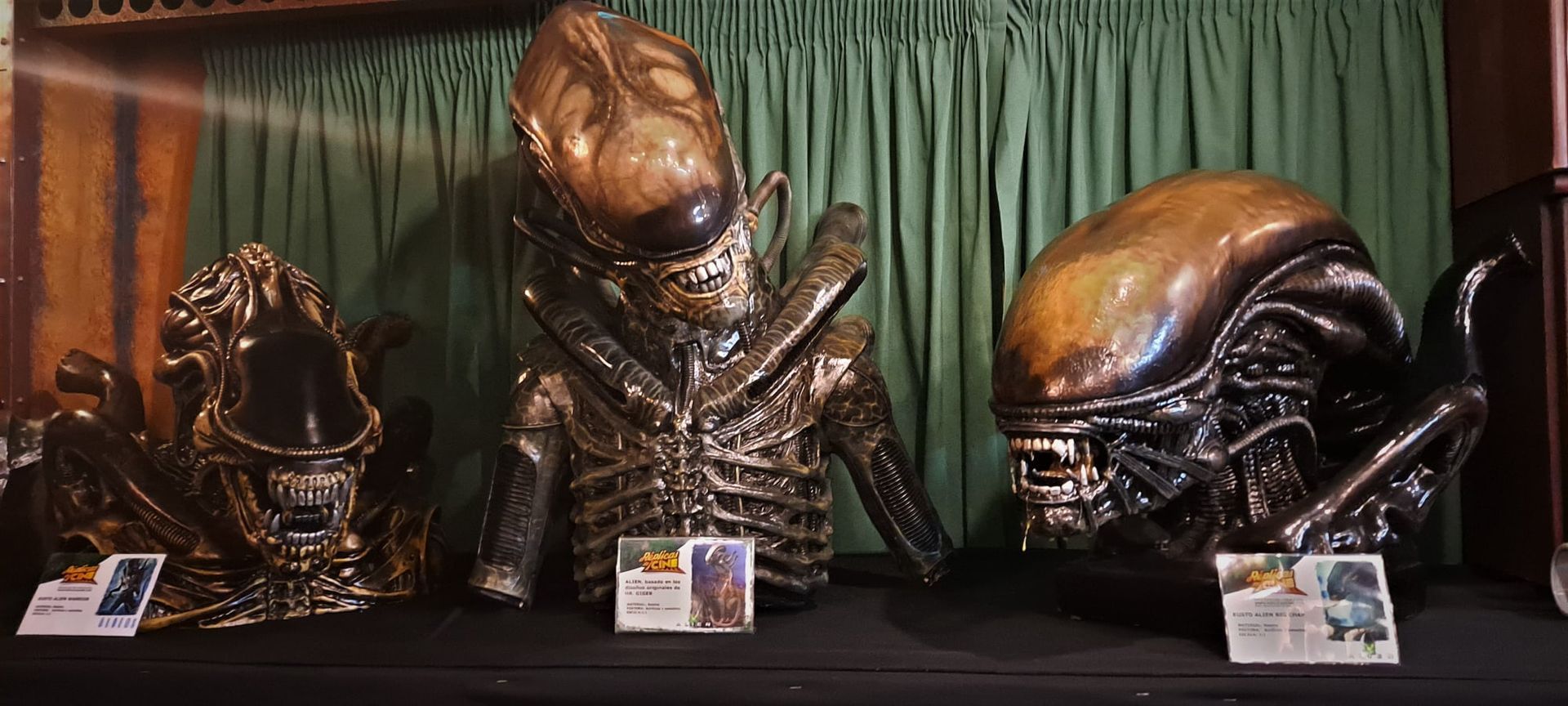 Tres estatuas de extraterrestres están sentadas en una mesa.