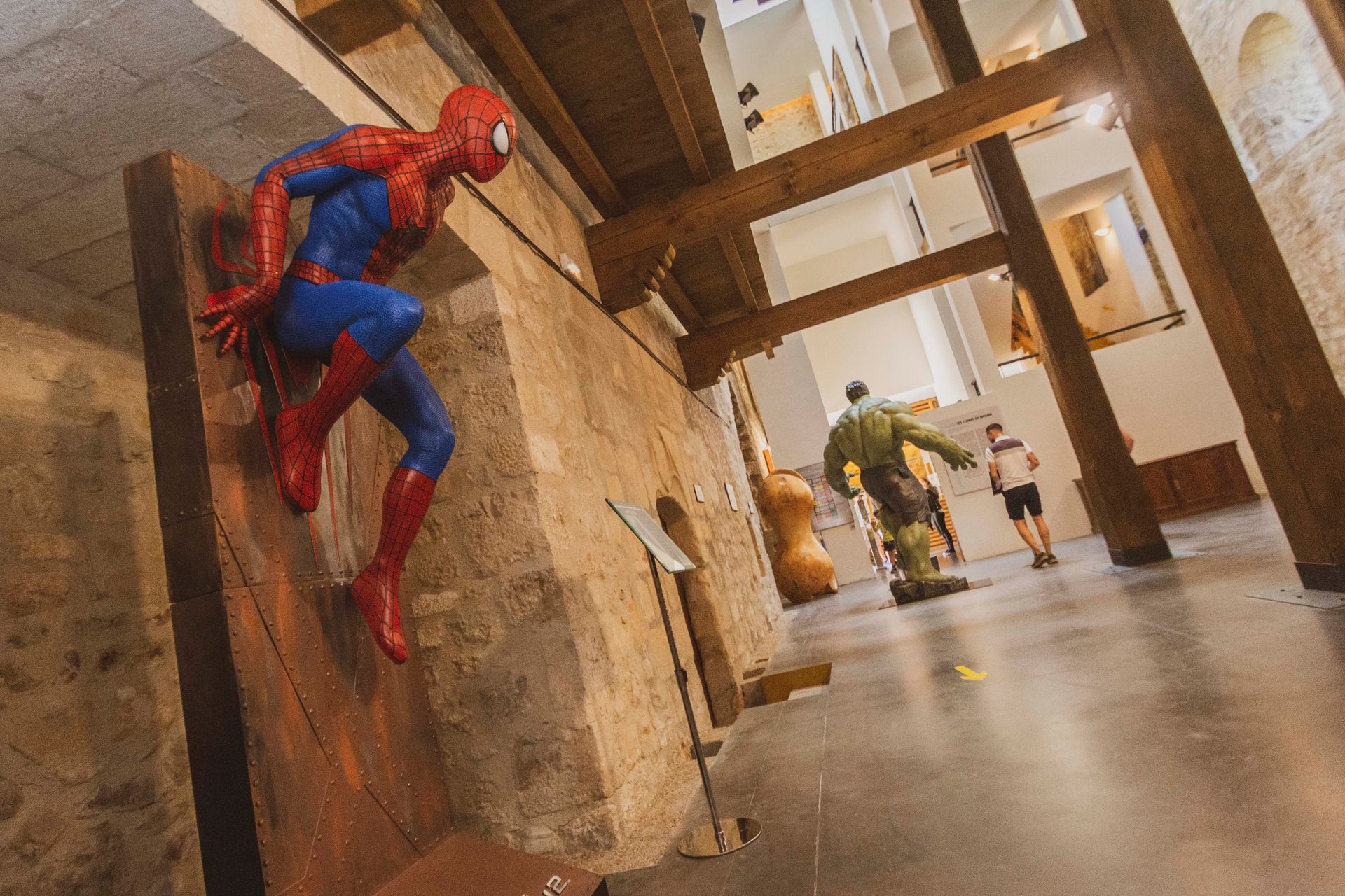 Una estatua del Hombre Araña está colgada en la pared de un museo.
