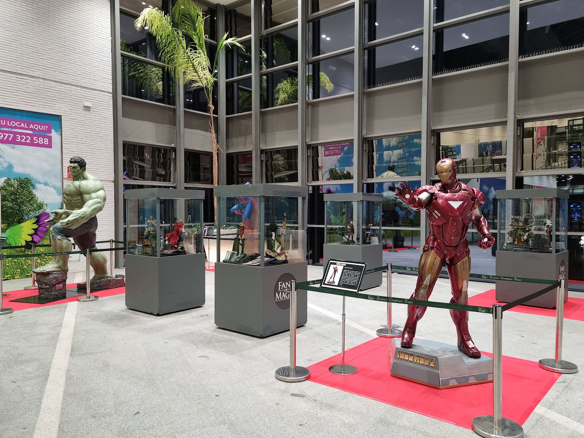 Una exhibición de estatuas de Hulk y Iron Man en un museo.