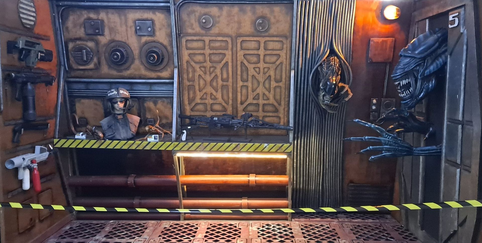 Una habitación con una estatua de un hombre y un extraterrestre dentro.