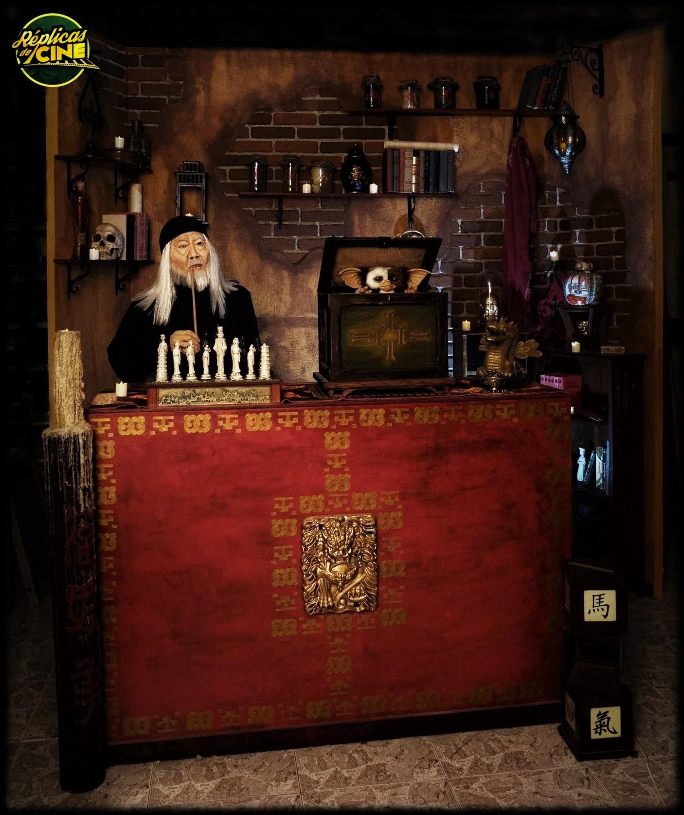 Un hombre con cabello largo y blanco se sienta detrás de una mesa roja.