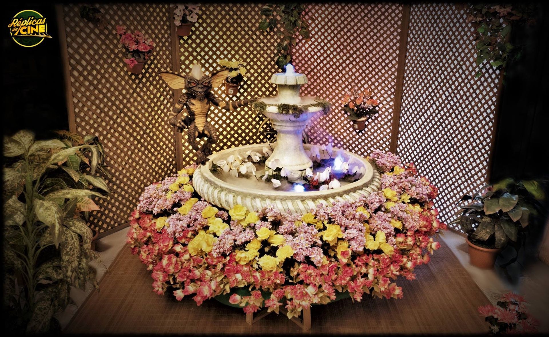 Una fuente está rodeada de flores sobre una mesa.