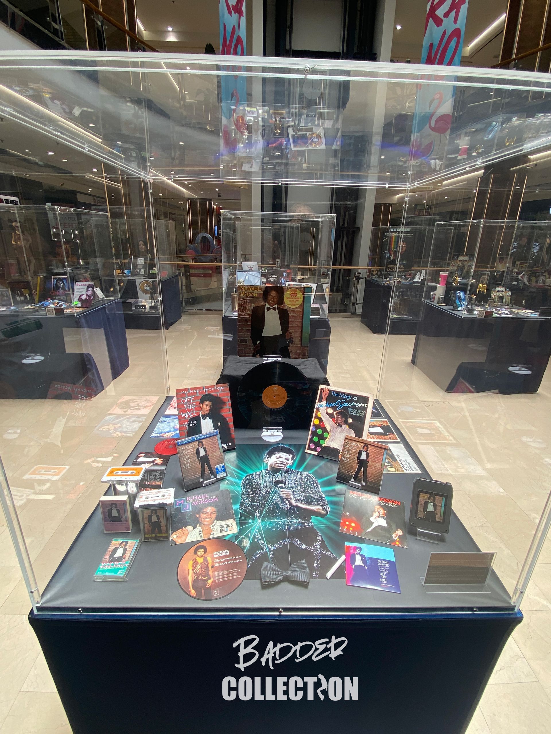 Una mesa con muchos objetos encima dentro de una vitrina de cristal.