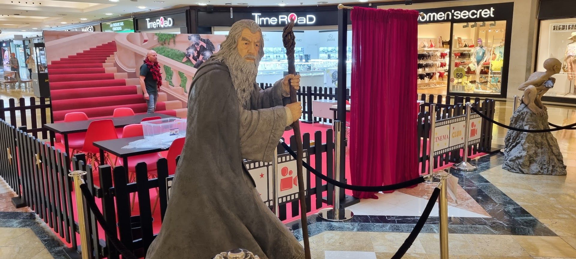 Una estatua de un hombre con barba está parada frente a una tienda.