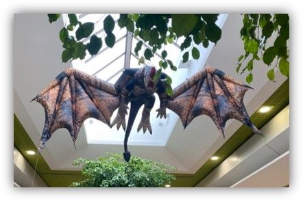 Un dragón de peluche cuelga del techo de un edificio.