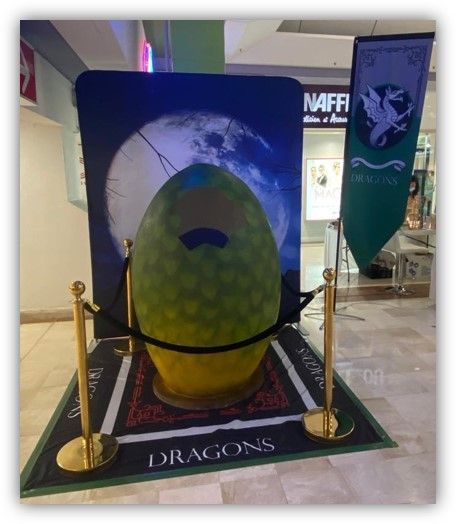 Un gran huevo de dragón se exhibe sobre una alfombra que dice dragones