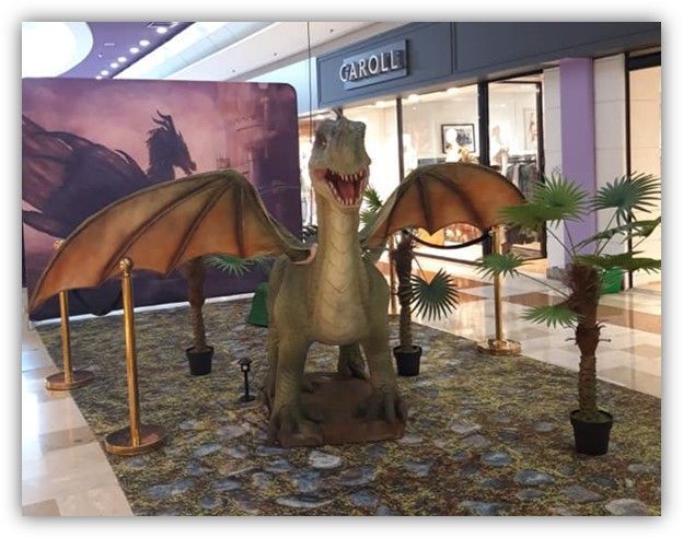 Una estatua de un dragón frente a una tienda llamada Catoll.