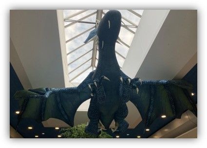 Un gran dragón de peluche cuelga del techo de un edificio.