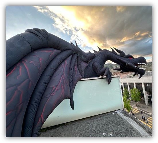Un gran dragón inflable está sentado en la parte superior de un edificio.