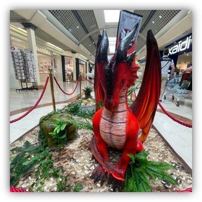 Una estatua de un dragón rojo en un centro comercial.