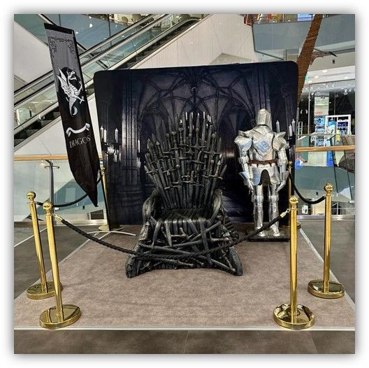 Un trono con un caballero de pie detrás de él.