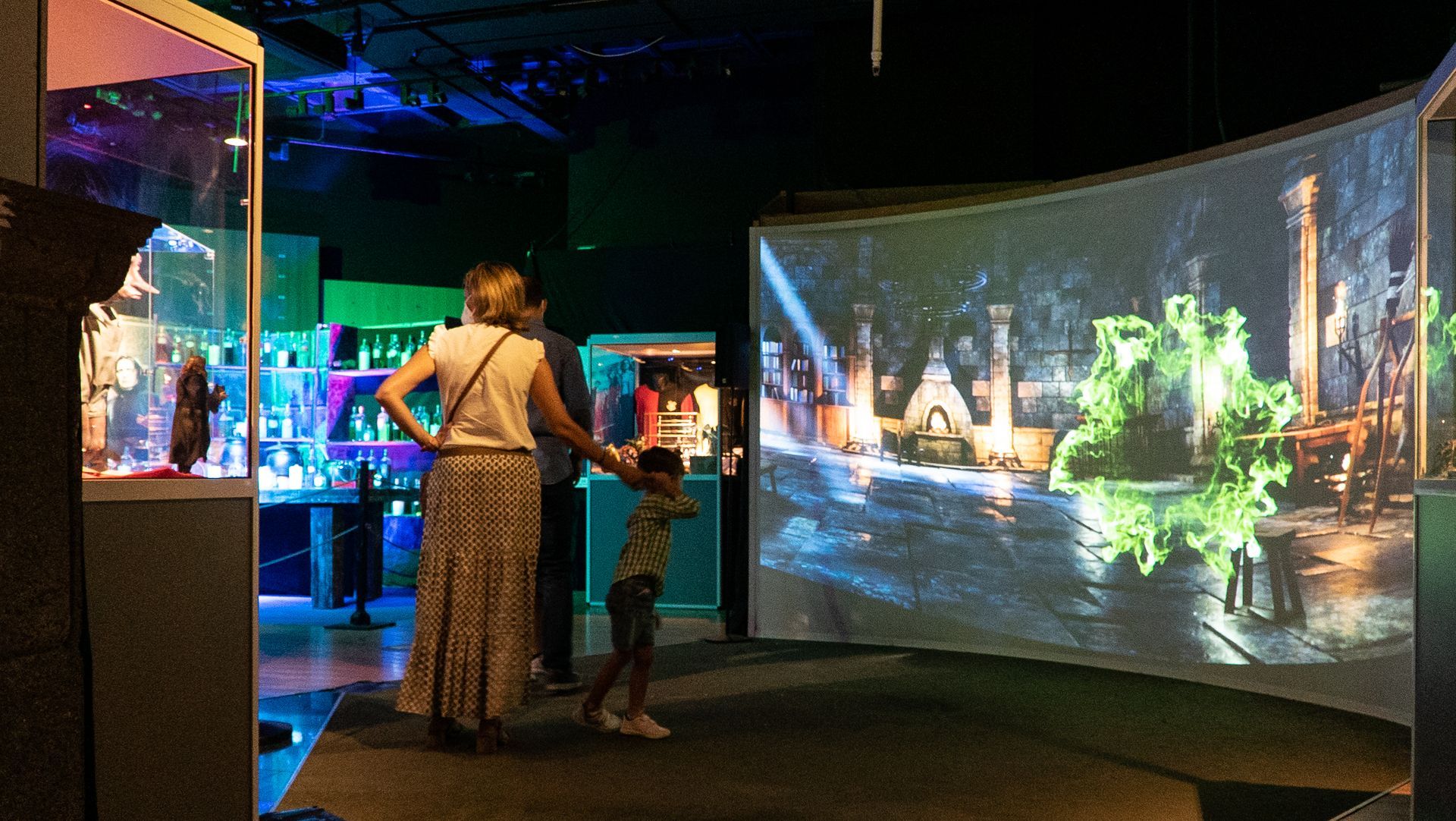 Un grupo de personas está de pie frente a una pantalla grande en un museo.
