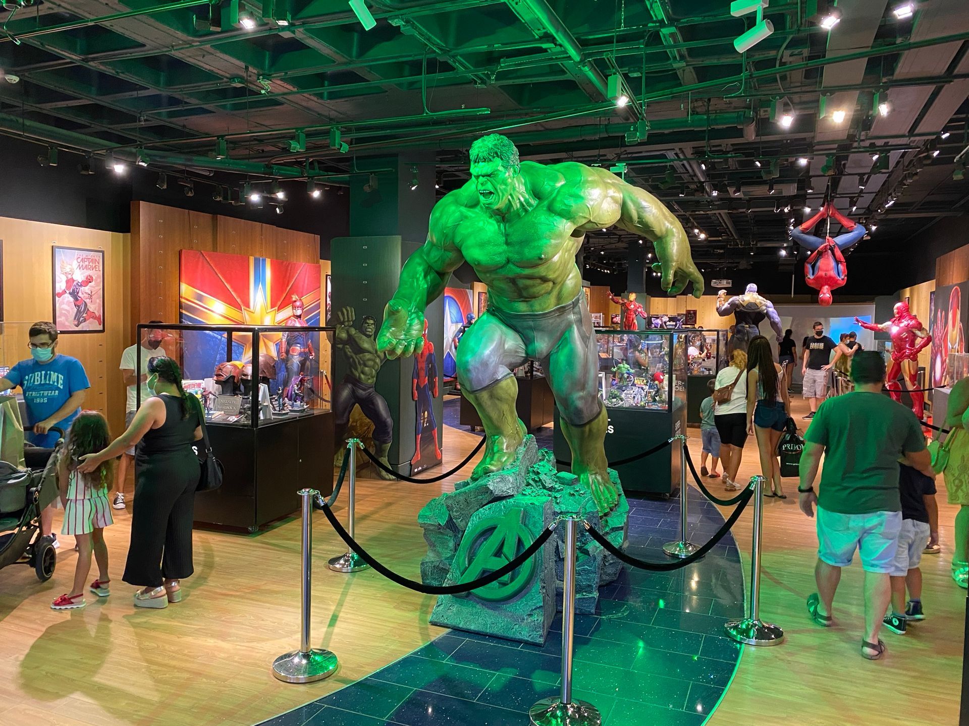 Un grupo de personas está de pie alrededor de una estatua del increíble Hulk.