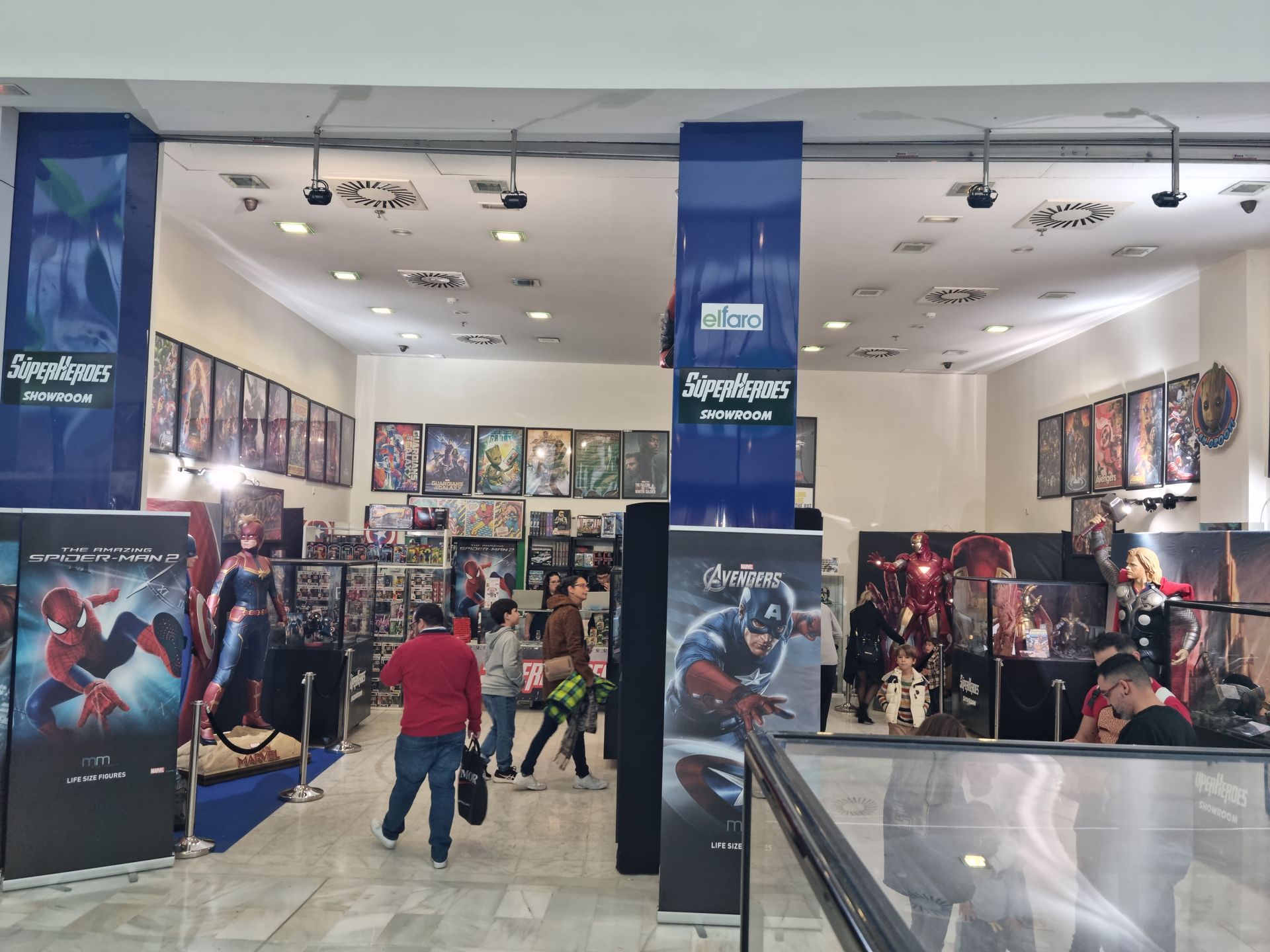 Un grupo de personas está de pie en una habitación con un póster del Capitán América en la pared.