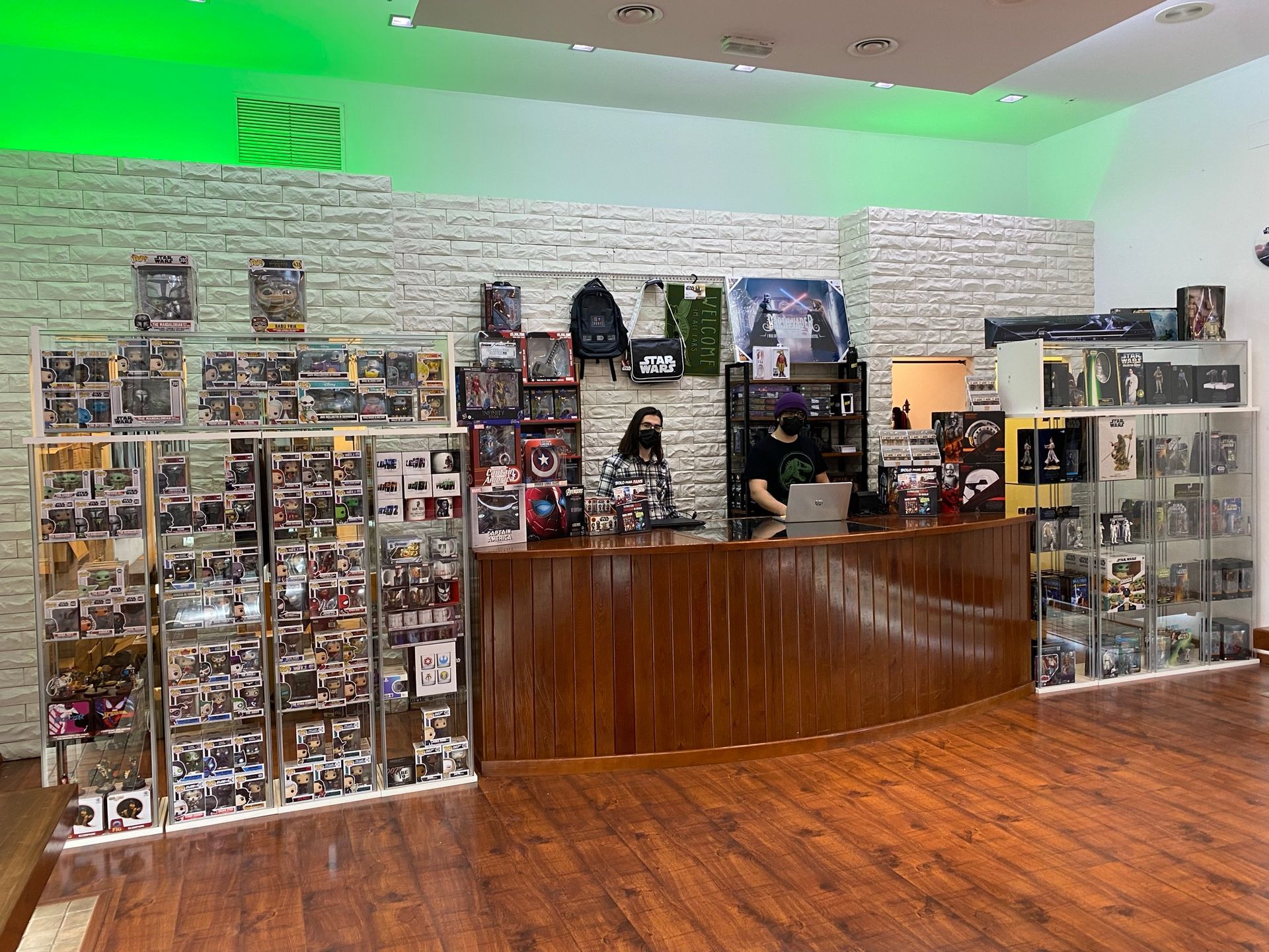 Un hombre está de pie frente a un mostrador en una tienda llena de artículos.