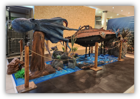 Un pulpo grande está sentado en lo alto de un tocón de árbol al lado de un submarino.