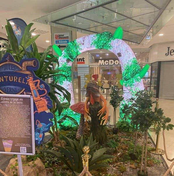 Una estatua de un dinosaurio frente a un McDonald's