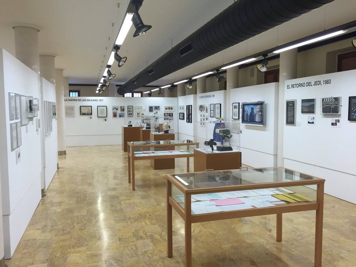 Una gran sala llena de mesas y vitrinas.