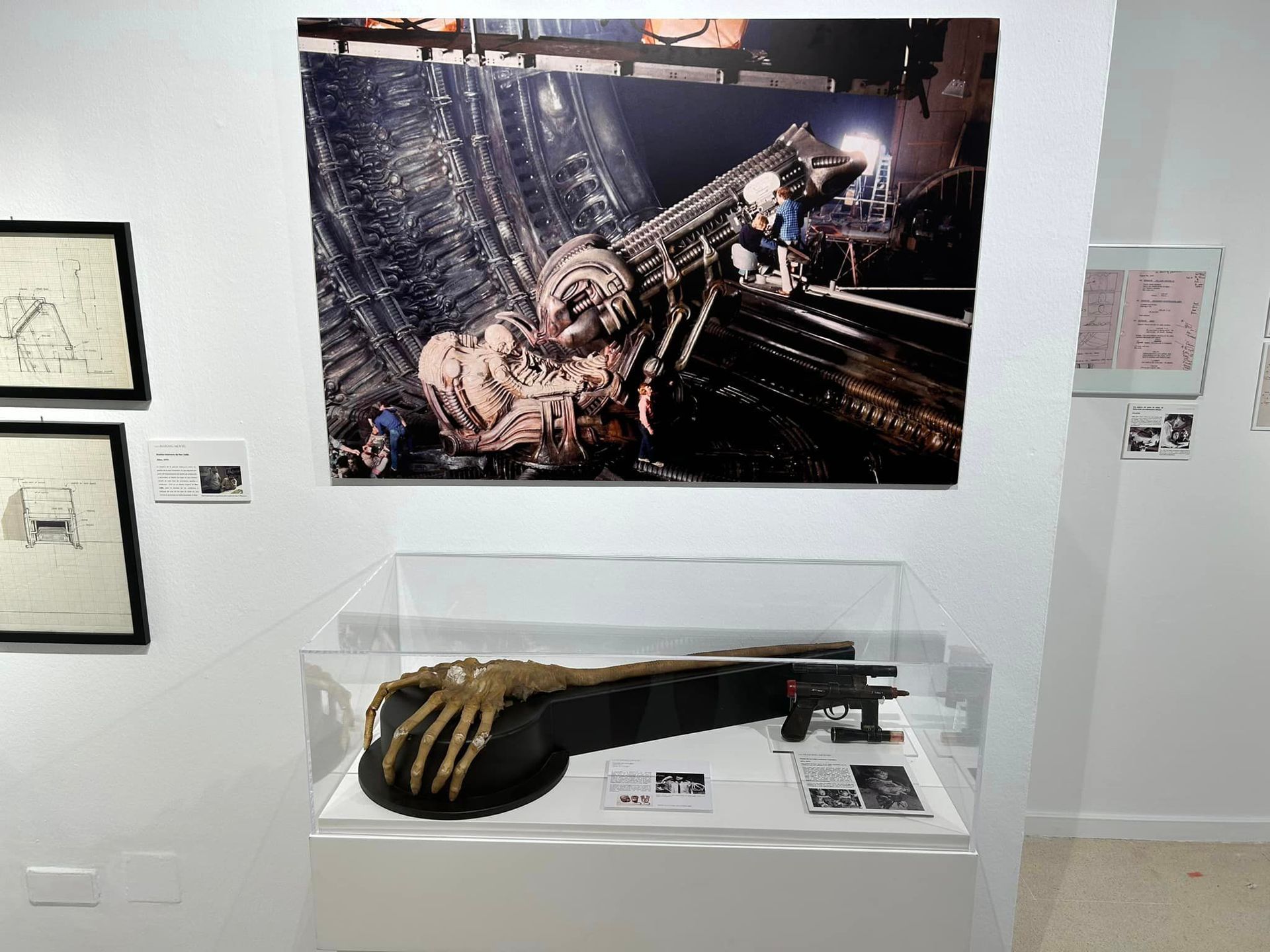 Una habitación con una vitrina y un cuadro en la pared.